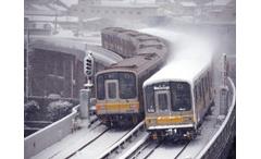 降り積もる雪の中、東山線高架をすれ違う５０５０形の写真です。
